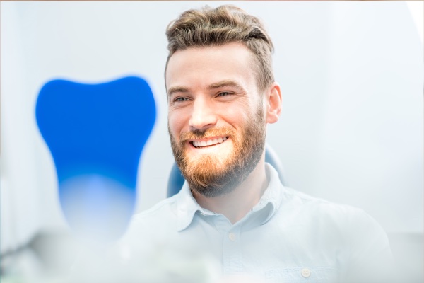 Man smiling into dental mirror